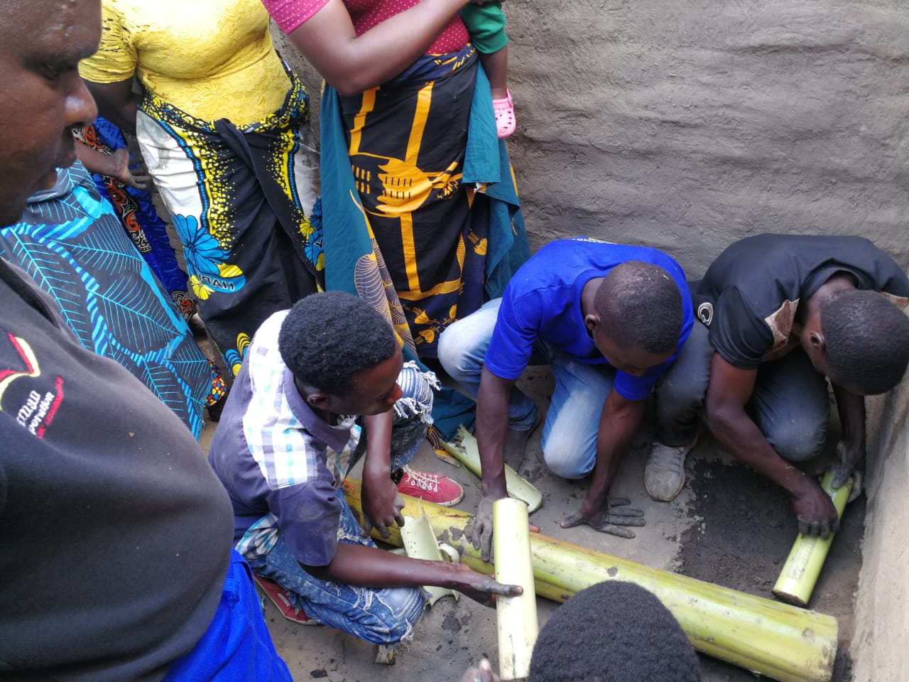 Women and youth learning how to make energy-saving cooking stoves